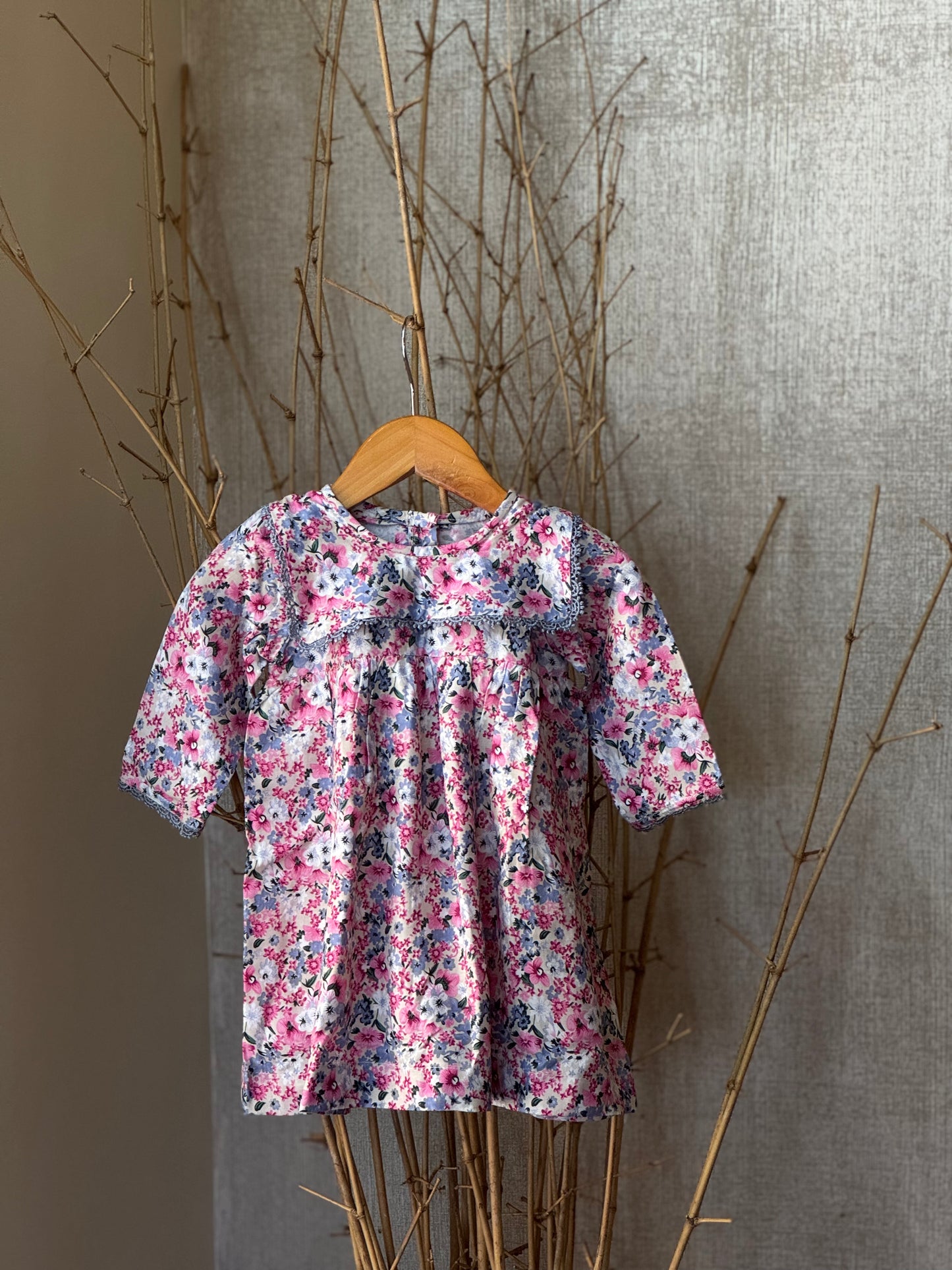 Floral cotton long-sleeve frock for girls with lace detailing, square yoke, and a pink-blue floral print—soft, breathable, and perfect for any occasion.