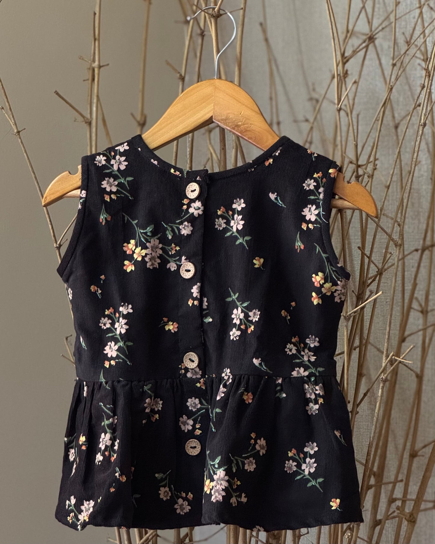 Girls’ black floral soft corduroy co-ord set with a sleeveless peplum top and high-waisted shorts—stylish, breathable, and perfect for any occasion.